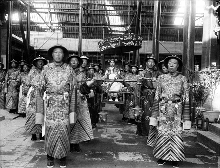 The Qing Dynasty Cixi Imperial Dowager Empress of China is carried and accompanied by palace eunuchs, before 1908 