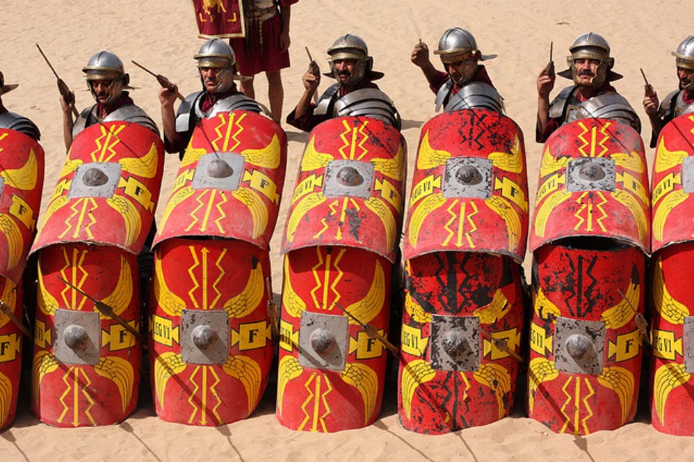 Roman Army reenactors in shielded formation, spears at the ready.