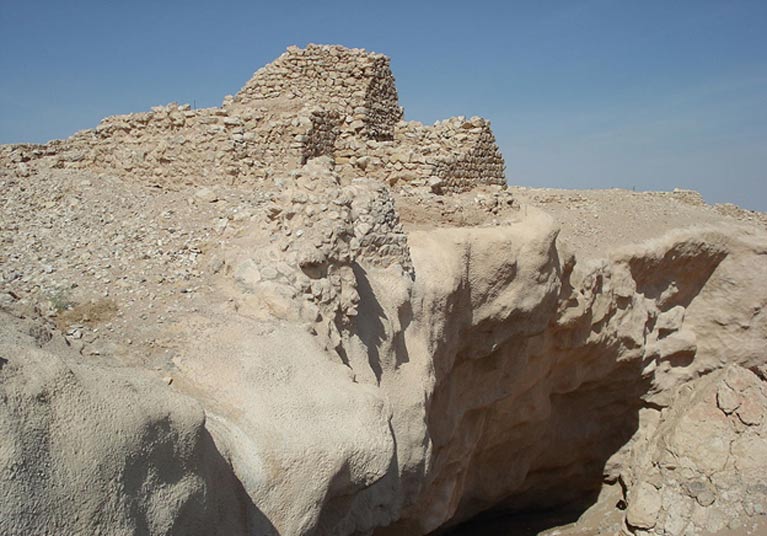 Shisr showing the sinkhole which dominates the site, and ruined walls above it. 