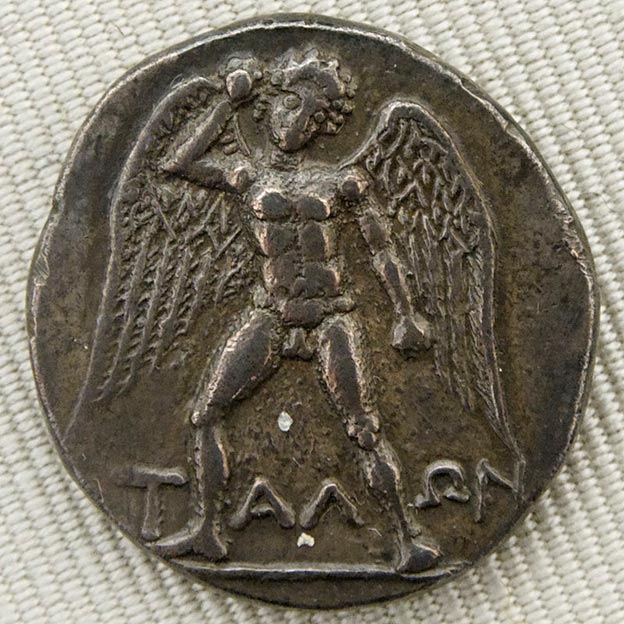 A coin featuring a large, winged Talos armed with a stone. The robot was built to repel invaders. Silver didrachma from Phaistos, Crete, circa 300/280-270 BC. 